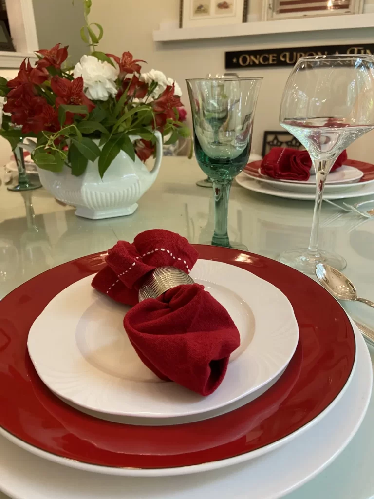 red and white table setting with flower arrangement