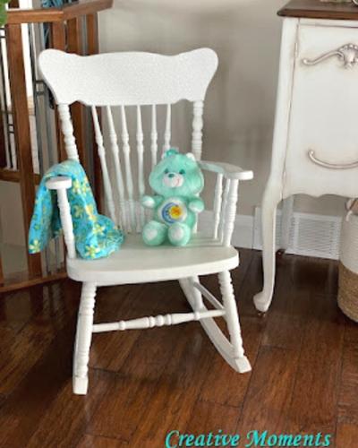upcycled home decor - a rocking chair made over with white paint and staged with stuffed animal and blanket