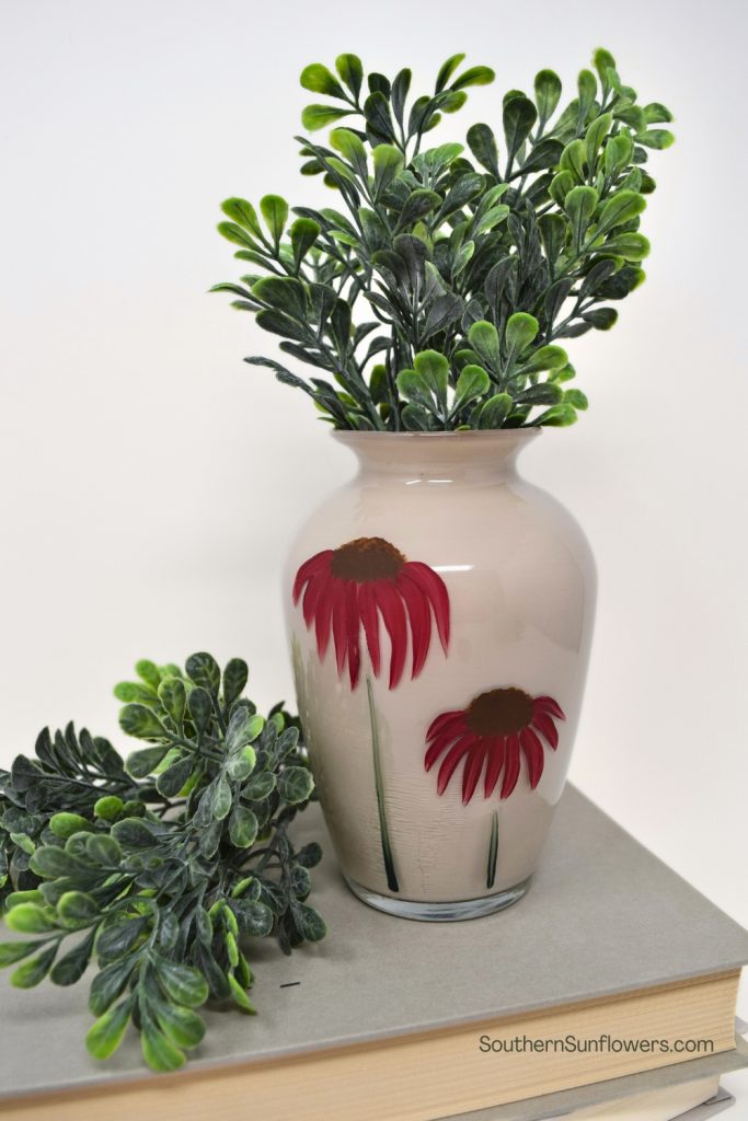 Painted glass vase staged with greenery
